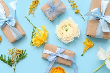 Paketlenmiş hediye kutuları ve arka planda bahar çiçekleri olan zarif kompozisyon