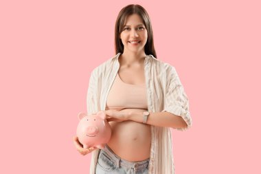 Pembe arka planda kumbarası olan hamile bir kadın. Annelik Faydası konsepti