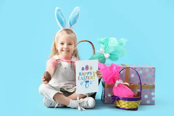 可爱的小女孩 戴着复活节彩蛋 戴着蓝色背景的礼物 长着一双小兔子耳朵 — 图库照片