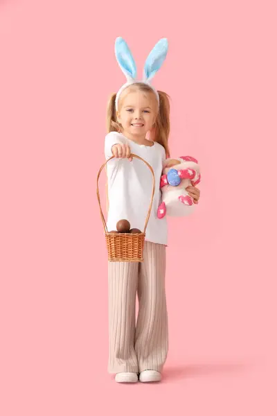 可爱的小女孩 长着小兔子耳朵 戴着巧克力复活节彩蛋 粉红背景的侏儒 — 图库照片