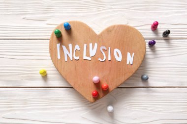 Kelime INCLUSION ile kalp ve beyaz ahşap arka plan üzerinde piyonlar
