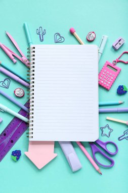 Mavi arkaplanda farklı kırtasiye malzemesi olan defter