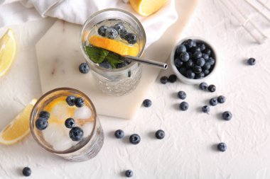 Taze yaban mersinli limonata ve beyaz arka planda böğürtlenli kase.