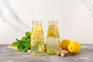 Gri masada zencefilli ve naneli limonata şişeleri.