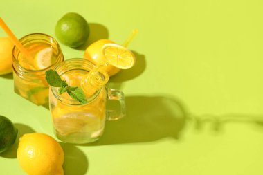 Yeşil arka planda naneli ve limonlu lezzetli limonata kavanozları