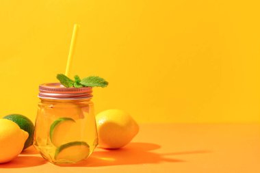 Renkli arkaplanlı limonata ve naneli Mason kavanozu.