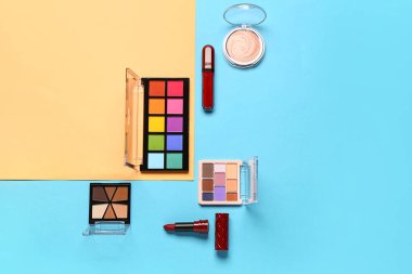 Güzel göz falı paletleri ve renkli arka planda farklı dekoratif kozmetikler.