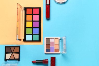 Güzel göz falı paletleri ve renkli arka planda farklı dekoratif kozmetikler.