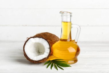 Beyaz ahşap arka planda hindistan cevizi kozmetik yağı dekanı