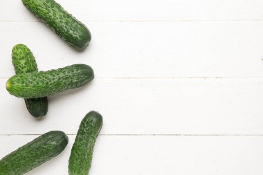 Beyaz ahşap zemin üzerinde taze salatalık