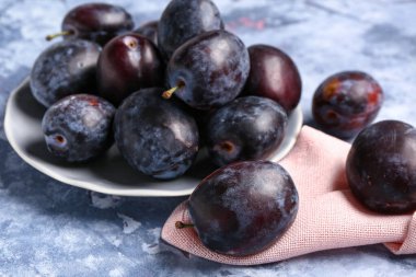 Mavi arka planda taze erik tabağı