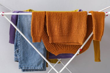 Temiz kış giysileri ışık duvarının yanındaki kurutucuda asılı.