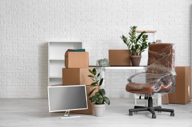Taşındığı gün koltuğu streç film ve karton kutulara sarılı olan ofis.