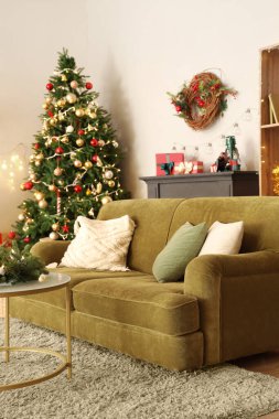 Kanepeli ve parıldayan Noel ağacıyla oturma odasının içinde.