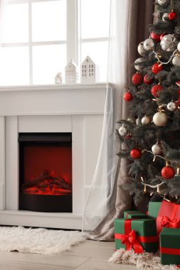 İçinde şömine, Noel ağacı ve hediyeler olan oturma odası.
