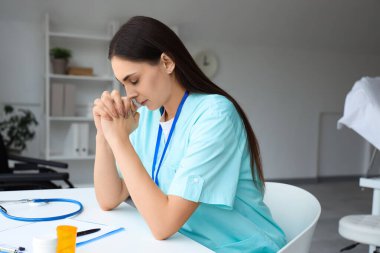 Klinikteki masada dua eden kadın hemşire.