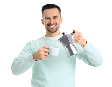 Yakışıklı adam gayzer kahve makinesinden beyaz arka planda fincana espresso dolduruyor.