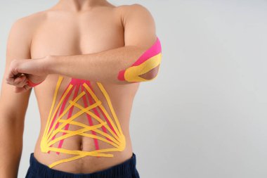 Arka planda fizyolojik bandı olan genç adam, yakın plan.