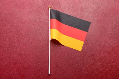 Koyu kırmızı zemin üzerinde Almanya bayrağı