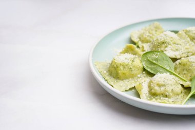 Beyaz arka planda peynirli lezzetli ravioli tabağı, yakın plan.