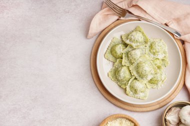 Beyaz zemin üzerinde peynir olan lezzetli bir ravioli tabağı.