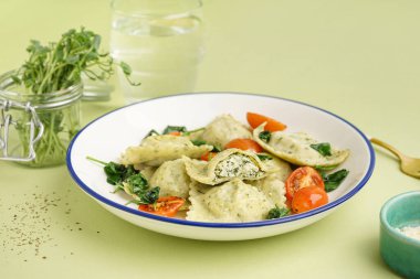 Yeşil arka planda sebzeli bir kase lezzetli ravioli.
