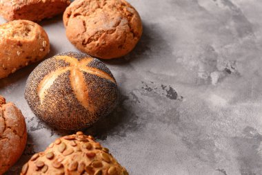 Gri grunge arka planında farklı taze çörekler.