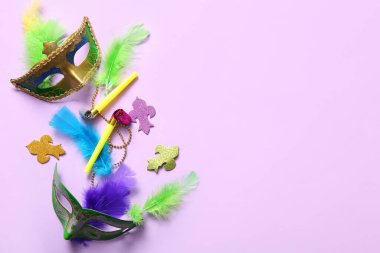 Mardi Gras kutlamaları için parti boynuzları ve dekorları olan karnaval maskeleri leylak arka planda