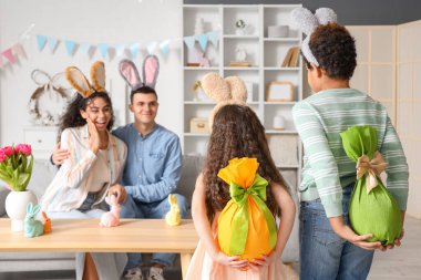 Paskalya Günü 'nde ailelerine hediye yumurtaları getiren küçük çocuklar.