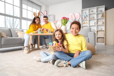 Paskalya yumurtalı küçük çocuklar ve aileleri evde