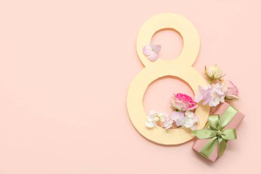 Hediye kutusu ve pembe arka planda farklı güzel çiçekler olan kağıttan yapılmış sekiz figür. Uluslararası Kadınlar Günü