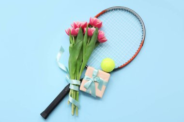 Tenis raketi, hediye kutusu ve Uluslararası Kadınlar Günü için lale çiçekleri.