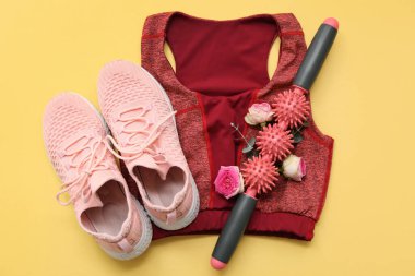 Vücut silindiri, spor sutyen, ayakkabı ve çiçeklerle renklendirilmiş kompozisyon. Uluslararası Kadınlar Günü