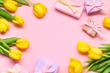 Hediye kutuları ve pembe arka planda sarı laleler.