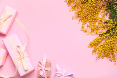 Pembe arka planda hediye kutuları ve mimozalar