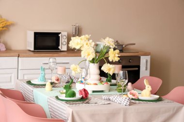 Çağdaş mutfakta çiçek vazosu ve Paskalya tavşanlarıyla şenlik masası.