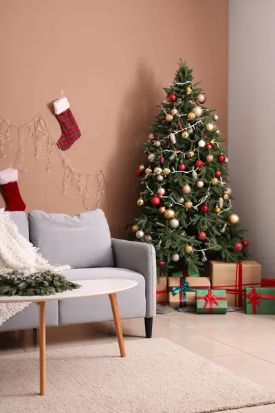 Interior of living room with sofa, Christmas tree and presents