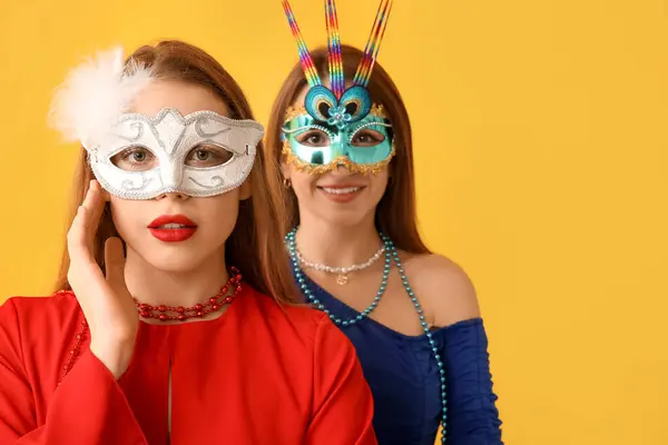 Hermosas Mujeres Jóvenes Máscaras Carnaval Sobre Fondo Amarillo —  Fotos de Stock