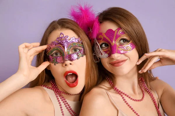 Hermosas Mujeres Jóvenes Máscaras Carnaval Sobre Fondo Lila —  Fotos de Stock