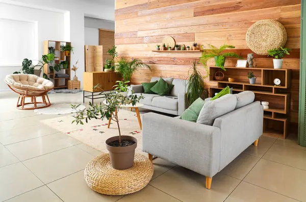 Interior of living room with green plants, sofas and table