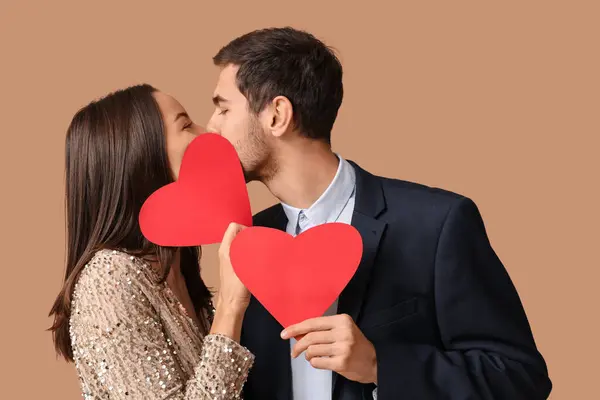 Beautiful Young Couple Kissing Red Paper Hearts Brown Background Valentine — Stock Photo, Image