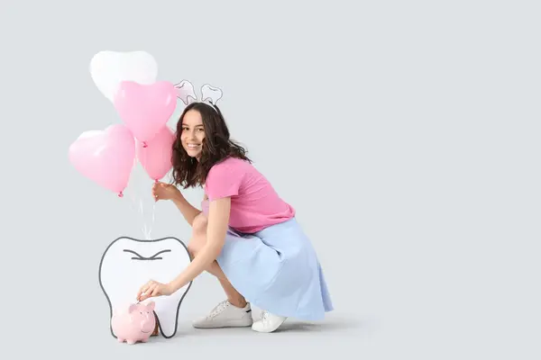 Fada Dos Dentes Com Balões Colocando Moeda Mealheiro Fundo Claro — Fotografia de Stock