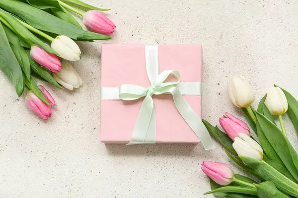 Hediye kutusu ve beyaz arka planda güzel laleler. Uluslararası Kadınlar Günü