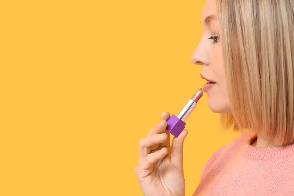 Vrouw Die Lippenstift Tegen Gele Achtergrond Aanbrengt — Stockfoto