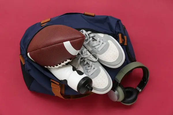 Αθλητική Τσάντα Μπάλα Ακουστικά Και Παπούτσια Κόκκινο Φόντο — Φωτογραφία Αρχείου