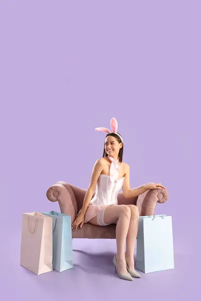 Sexy Young Woman Bunny Costume Shopping Bags Sitting Lilac Background — Stock Photo, Image