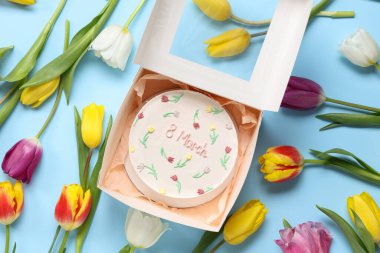 Tatlı bento kekli bir kutu ve mavi arka planda güzel laleler. Uluslararası Kadınlar Günü