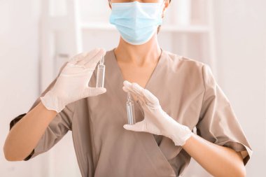 Güzellik salonunda tıbbi maskesi ve ampulleri olan kadın kozmetik uzmanı.