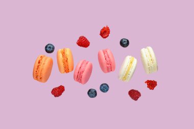 Leylak arkaplanda tatlı badem kurabiyeleri ve böğürtlenler uçuşuyor.