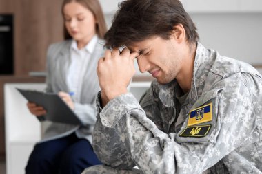 Ofisteki psikologla randevusu olan üzgün erkek asker.